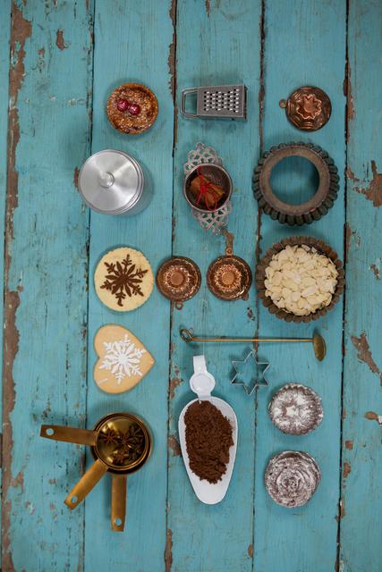 Various items and ingredients to prepare christmas cookies on a wooden plank