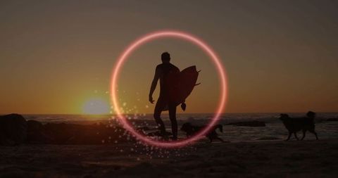 Surfer silhouette on beach at sunset with neon ring and dogs