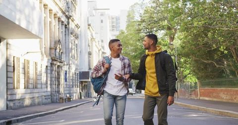 Two Friends Walking in City Street with Backpacks - Download Free Stock Images Pikwizard.com