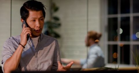 Focused Businessman Discussing Strategy on Smartphone in Modern Office