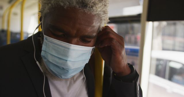 Senior man wearing a face mask and using public transportation, symbolizing safety habits during pandemic. Ideal for topics on public health, commuting safety, elderly well-being, and pandemic response.