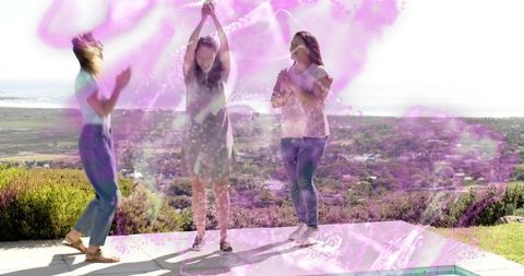 Three friends jumping and celebrating on sunlit hillside terrace with pink color splash