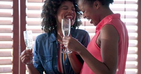 African American Women Celebrating with Champagne at Home