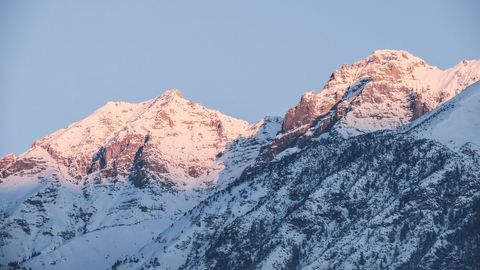 Sunrise Casting Warm Glow on Snow-Capped Mountain Peaks