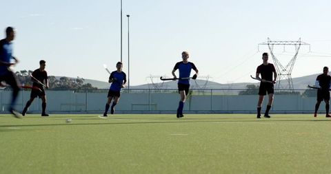 Team practice on synthetic turf field under clear sky