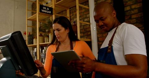 Colleagues Collaborating with Digital Technology in Coffee Shop