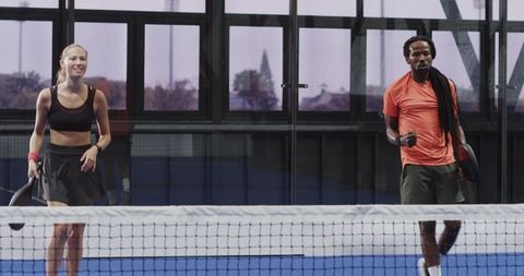 Diverse padel players celebrating victory on indoor court