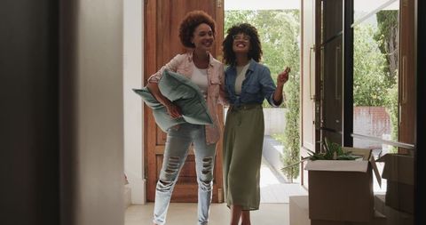 African American Friends Moving Into New Home Celebrating at Front Door with Boxes and Plants