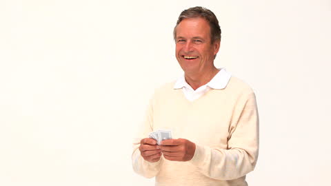 Smiling Mature Man Holding Playing Cards in Hands