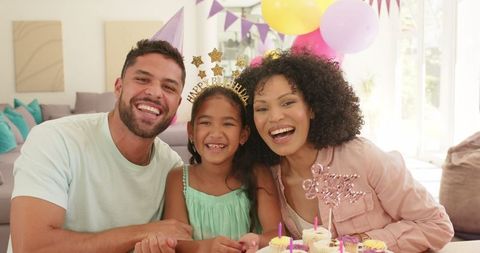 Joyful family celebrating daughter's birthday at home