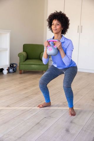 Woman Doing Kettlebell Squats at Home for Strength Training