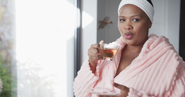 Woman Enjoying Hot Beverage in Cozy Pink Robe by Window - Download Free Stock Images Pikwizard.com