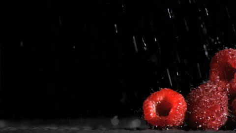 Fresh Raspberries with Water Droplets Against Black Background