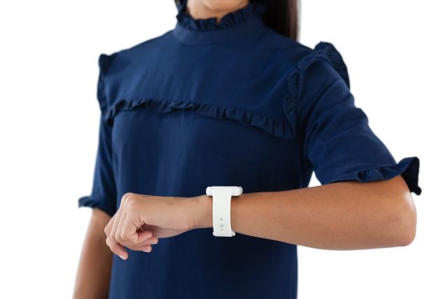 This image shows a female executive checking her smartwatch, highlighting the use of modern technology in professional settings. Ideal for articles or advertisements related to business, time management, wearable technology, and professional attire.