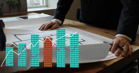 Business team reviewing blueprints with overlaid financial bar chart and trend lines