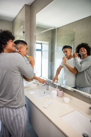 African American Friends Brushing Teeth in Modern Bathroom