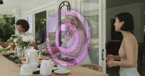 Senior woman arranging tea and desserts on patio with friends amid purple holographic hud