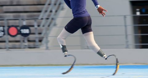 Athlete with Prosthetic Legs Sprinting on Track
