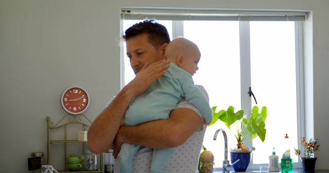 Father Comforting Baby in Bright Modern Kitchen - Download Free Stock Images Pikwizard.com