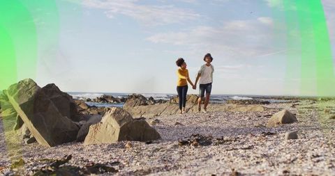 Couple Relaxing on Rocky Shoreline Holding Hands