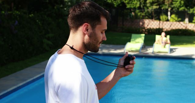 Young Man Timing at Swimming Pool using Stopwatch Outdoors - Download Free Stock Images Pikwizard.com