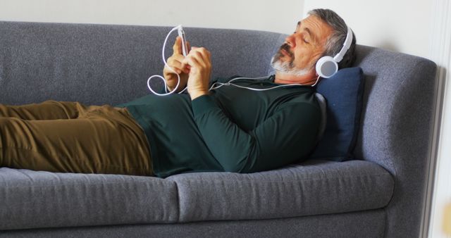 Senior Man Relaxing on Sofa with Headphones and Smartphone - Download Free Stock Images Pikwizard.com