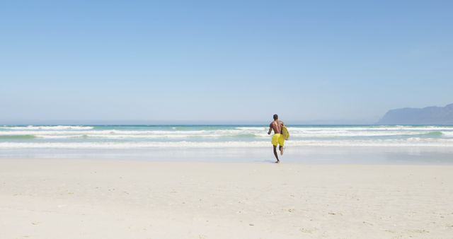 Man Running Towards Ocean on Sunny Beach - Download Free Stock Images Pikwizard.com