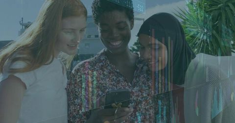 Diverse Women Collaborating on Technology in Urban Environment