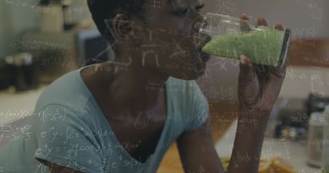 African American Woman Drinking Green Juice with Math Equations Overlay