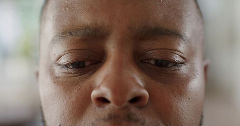 Closeup African American Man Looking Downward Showing Natural Skin Texture, Pores, Stubble
