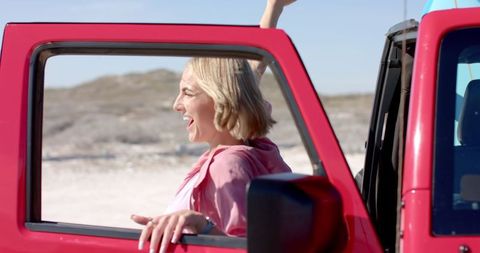 Woman Relishing Beach Drive in Red Car, Cheerful and Free