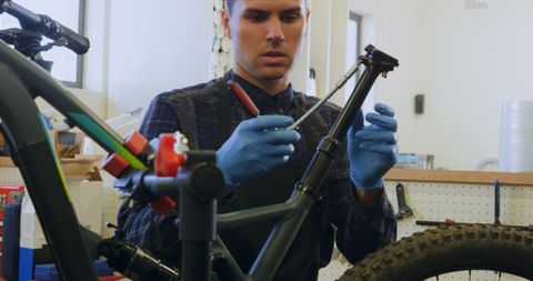 Mechanic skillfully repairing bicycle frame in workshop
