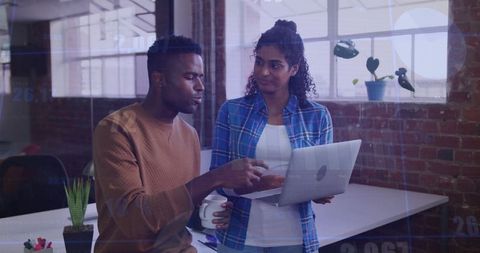 Collaborative Colleagues Analyzing Data on Laptop Screen in Modern Loft Office