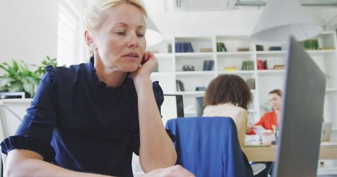 Focused Businesswoman Using Laptop in Modern Office