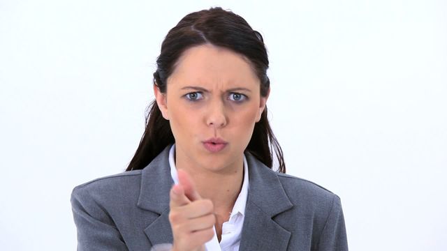 Businesswoman in formal attire showing anger and determination. Useful for depicting workplace conflict, frustration, and assertiveness. Suitable for articles or presentations on business challenges, employee relations, and conflict resolution.