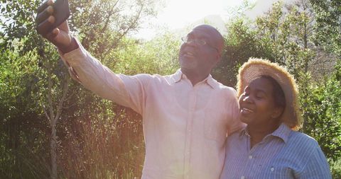 Senior Couple Taking Selfie Outdoors in Sunny Garden