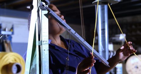 Focused Technician Adjusting Mechanical Equipment in Industrial Setting