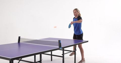 Professional athlete playing table tennis match indoors