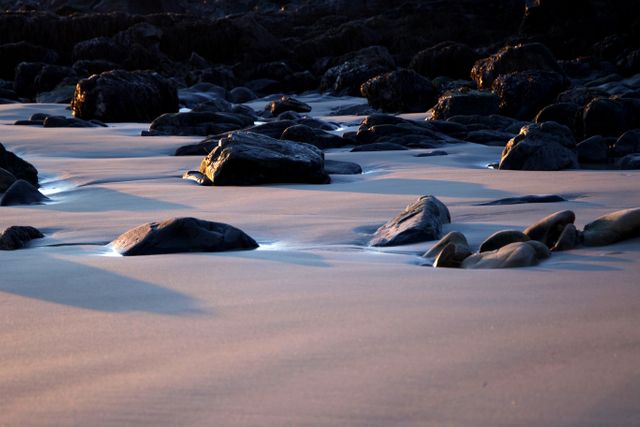 Black Rocks on Sand during Daytime - Download Free Stock Photos Pikwizard.com