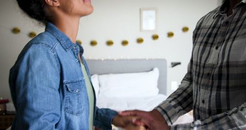 Happy Couple Celebrating Anniversary Holding Hands at Home