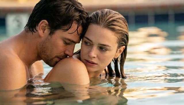 Holding couple embracing in pool at golden hour intimate resort romance with reflections