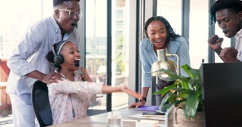 Diverse Team Celebrating Success at Workplace with Joy and Excitement