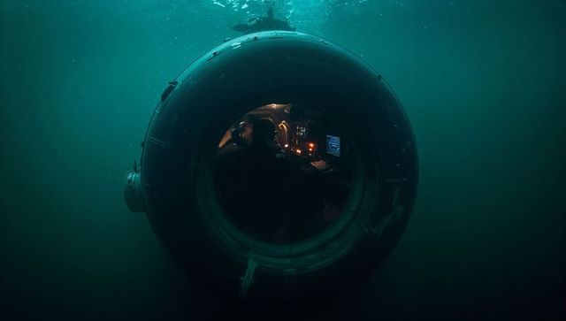 Operating spherical submersible cockpit through porthole underwater with instrument glow
