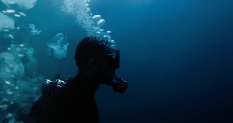 Scuba Diver Navigating Underwater with Jellyfish Drift