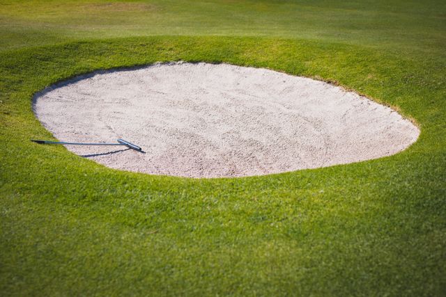 The sand bunker at a golf course with a rake in it. golf sports hobby, healthy active lifestyle.