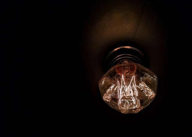 Glowing Vintage Light Bulb in Dark Room - Download Free Stock Photos Pikwizard.com