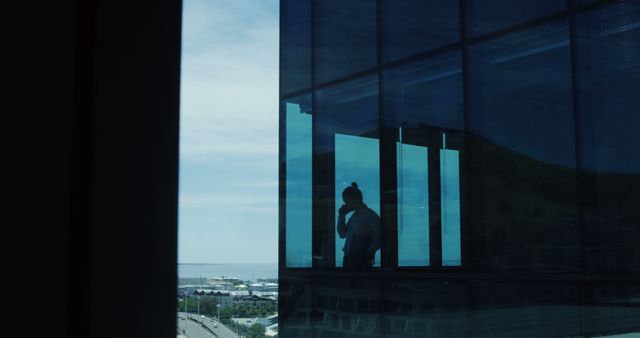 Silhouette of Person on Phone in Modern Office Building with Cityscape View - Download Free Stock Images Pikwizard.com
