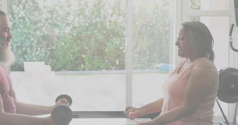 Senior couple lifting dumbbells in bright home gym promoting active healthy aging