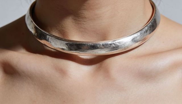 Hammered silver choker on female neck highlighting collarbone and textured shine