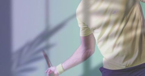 Action shot of tennis player holding racket in bright studio light